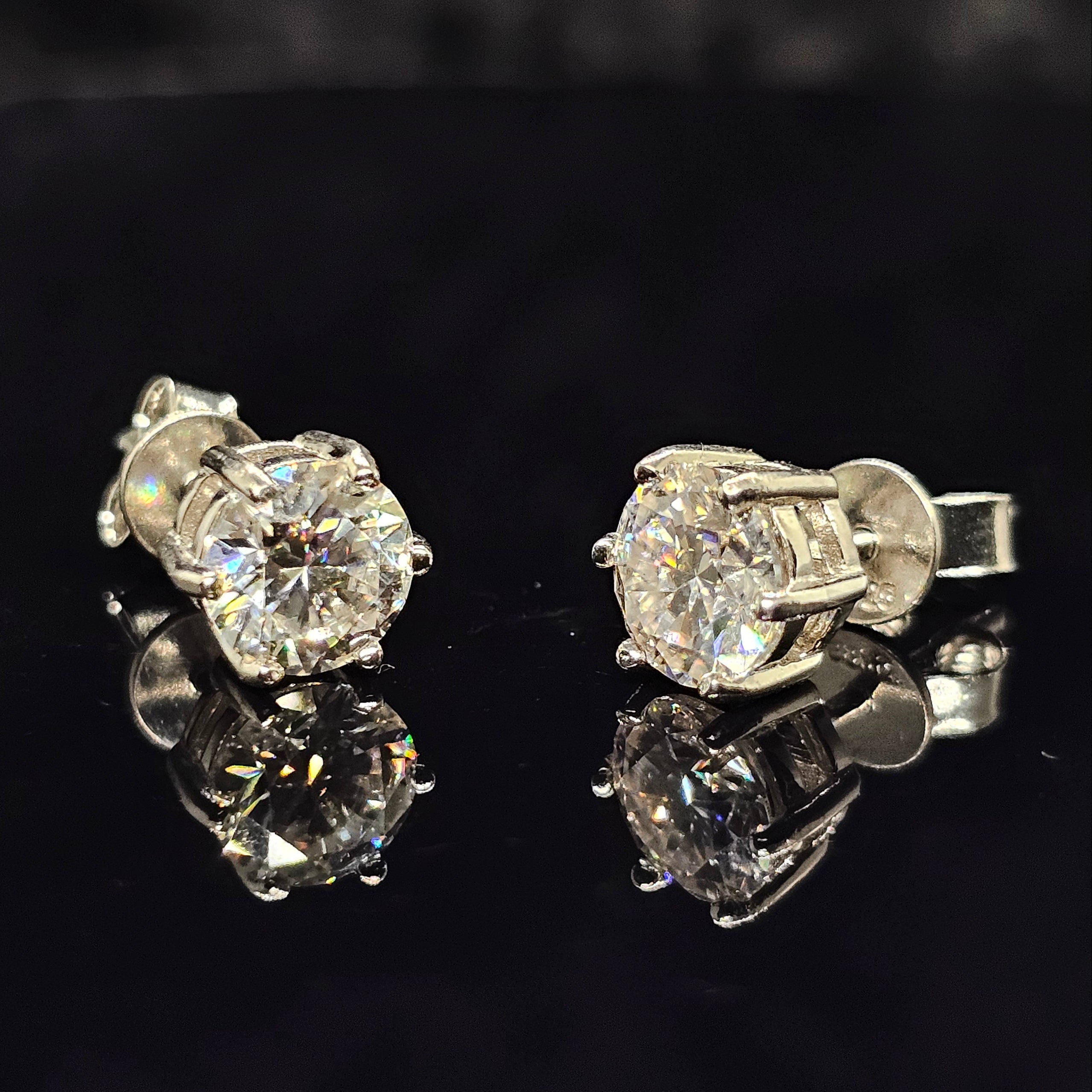 Pair of diamond stud earrings on a black background